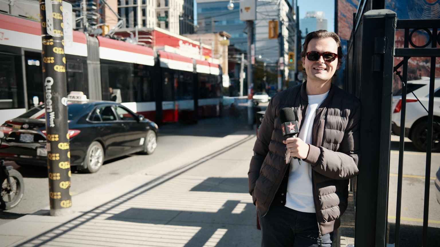 Myles holding a microphone on a Toronto street